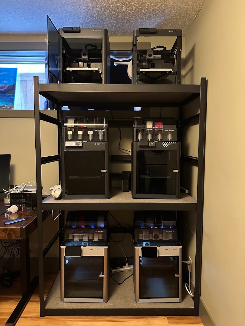 A steel rack holding six Bambu Lab 3D printers